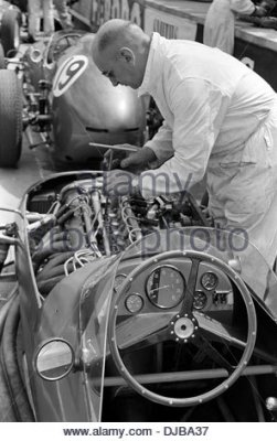 a-mechanic-working-on-aston-martin-dbr5-cars-in-the-pits-at-the-british-djba37.jpg