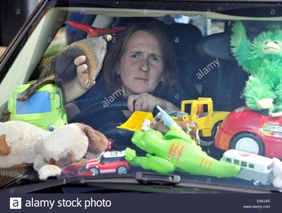 stressed-mother-overwhelmed-by-piles-of-kids-toys-in-her-car-peeps-E5KJK6.jpg